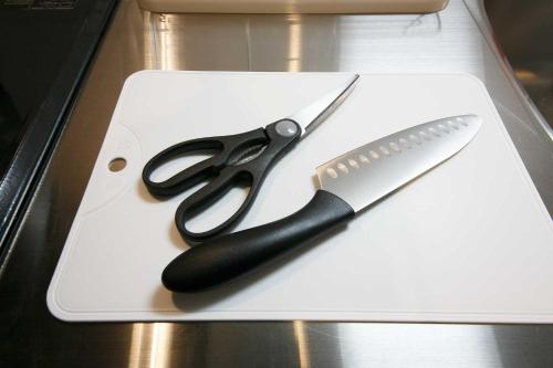 a pair of scissors and a knife on a white cutting board at Twinberry CHITOSE in Chitose