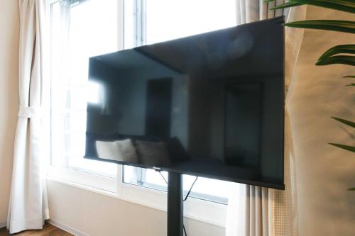 a flat screen tv sitting in front of a window at Twinberry CHITOSE in Chitose