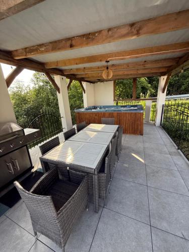 a patio with a table and chairs and a grill at Pod Skałką in Sromowce Wyżne