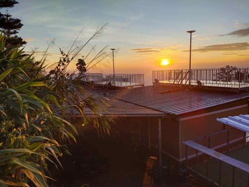 a sunset over a beach with a deck and a bench at สเตชั่นภูทับเบิก-บ้านดาดฟ้าทะเลหมอก in Ban Tha Kok Hai