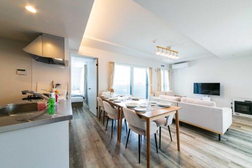a kitchen and a living room with a table and a couch at Twinberry CHITOSE in Chitose