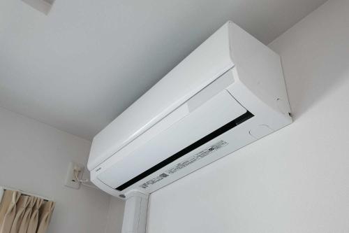 a white microwave oven hanging from a ceiling at Twinberry CHITOSE in Chitose