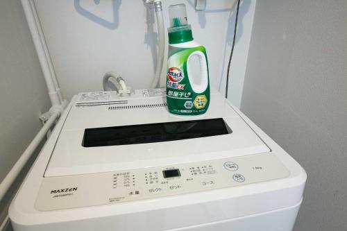 a bottle of laundry detergent sitting on top of a washing machine at Twinberry CHITOSE in Chitose