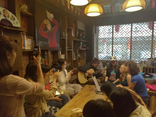 a group of people sitting around a table in a room at Zhangjiajie Jijiehao Inn in Zhangjiajie