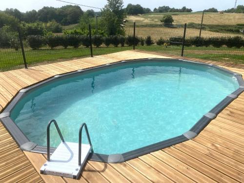 - une grande piscine avec une chaise dans la cour dans l'établissement Maison à la campagne avec piscine et jacuzzi, à Cadouin