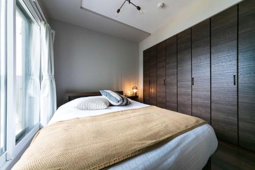 a bedroom with a large bed with a large window at Twinberry CHITOSE in Chitose