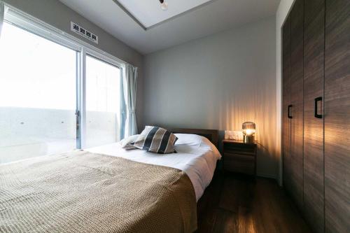 a bedroom with a bed and a large window at Twinberry CHITOSE in Chitose