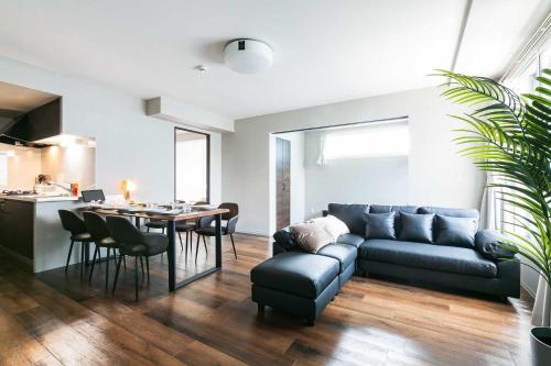 a living room with a couch and a table at Twinberry CHITOSE in Chitose