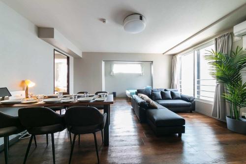 a living room with a table and a couch at Twinberry CHITOSE in Chitose