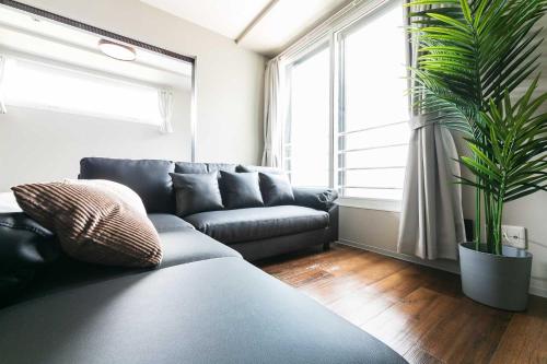 a living room with a couch and a large window at Twinberry CHITOSE in Chitose