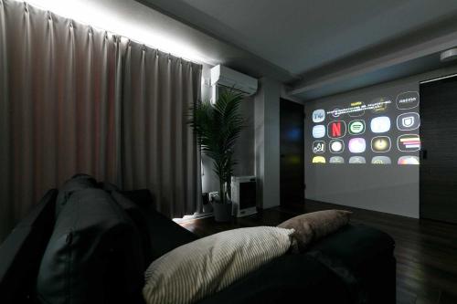 a living room with a couch and a television at Twinberry CHITOSE in Chitose