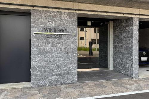 a brick building with a sign on the side of it at Twinberry CHITOSE in Chitose