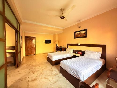 a hotel room with two beds and a tv at Pameer Hotel Mingora in Mingora