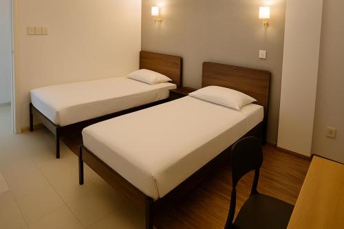 a room with two beds and a chair in it at Arrival View in Male City