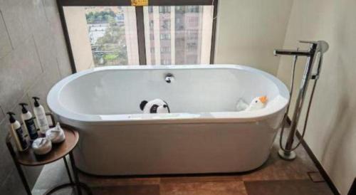 a white bath tub in a bathroom with a window at Wanda JIN Baise in Baise