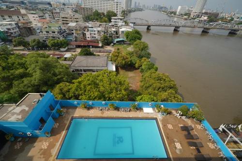 an overhead view of a swimming pool next to a river at Riverside Bangkok Hotel in Bangkok