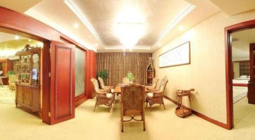 a dining room with a table and chairs at Junyu Grand Hotel Qinhuangdao in Qinhuangdao