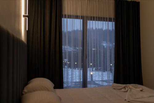 a bedroom with a bed and a large window at Краєвид in Slavske