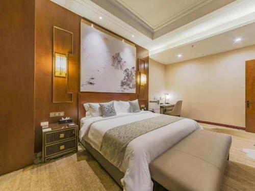 a hotel room with a large bed and a desk at YUN-RAY Hotel Shijiazhuang in Shijiazhuang