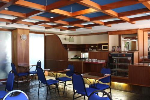 斯里巴加灣市的住宿－銀禧酒店，一间配备有蓝色椅子和桌子的用餐室