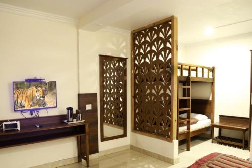 a room with a bed and a dressing table and a mirror at Hotel Aroma Nainital In house parking in Nainital