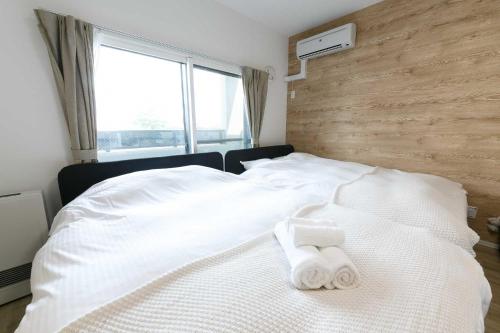 a bedroom with a white bed with towels on it at EFFECT minami7 in Sapporo