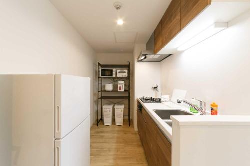 a kitchen with a sink and a refrigerator at EFFECT minami7 in Sapporo