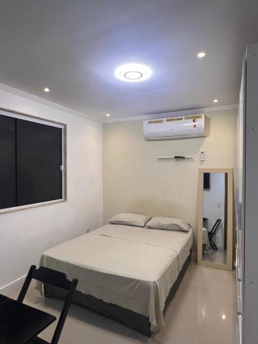 a bedroom with a bed and a flat screen tv at Suíte 3 Residencial in Nova Iguaçu