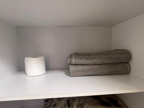 a shelf with two towels and a roll of paper towels at Suíte 3 Residencial in Nova Iguaçu