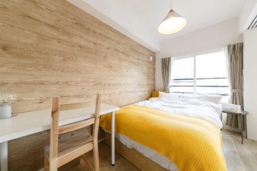 a bedroom with a yellow bed and a desk at EFFECT minami7 in Sapporo