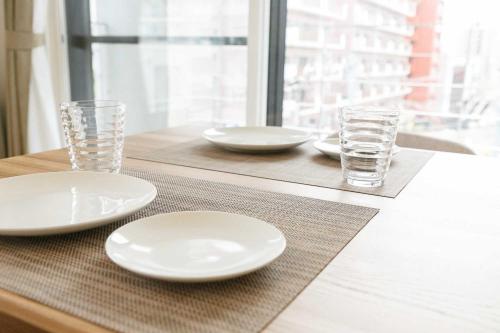 a table with white plates and glasses on a table at EFFECT minami7 in Sapporo