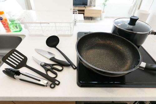 a frying pan sitting on a stove with utensils on a counter at EFFECT minami7 in Sapporo