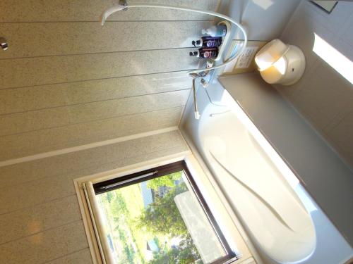 a bathroom with a toilet and a window at Yamagataya in Kitakata
