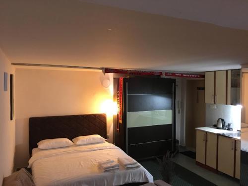 a bedroom with a large bed and a kitchen at City Center apartment in Podgorica