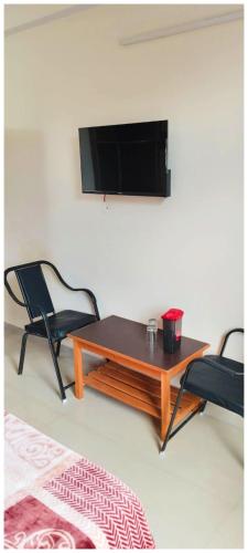 a living room with a coffee table and two chairs at HOTEL #KRISHNA B&B Śhimla Near Mall Road- Free Wi-fi And Restaurant & Mountain View -Best Hotel In Śhimla! in Shimla