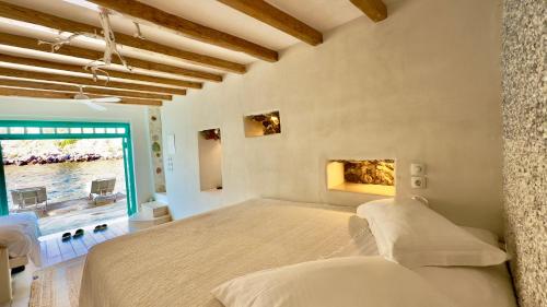 a bedroom with a large bed and a window at Milos Boathouse-Between2seas Boutique in Areti