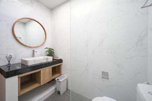 a bathroom with a sink and a mirror at De Luxora Villa Canggu in Kerobokan