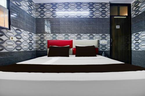 a bedroom with a large bed with a red headboard at Hotel O K10 Grand in Ludhiana