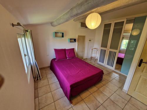 - une chambre avec un lit violet dans l'établissement Provençal house with pool, à Sauveterre