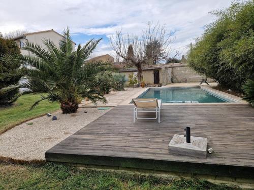 une chaise assise sur une terrasse à côté d'une piscine dans l'établissement Provençal house with pool, à Sauveterre