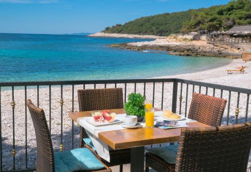 a table on a balcony with a view of the beach at B&B Zora Panoramic View in Milna