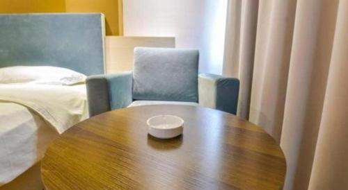 a room with a table and a chair and a bed at JTOUR Inn Guilin Two Rivers and Four Lakes Walmart in Guilin