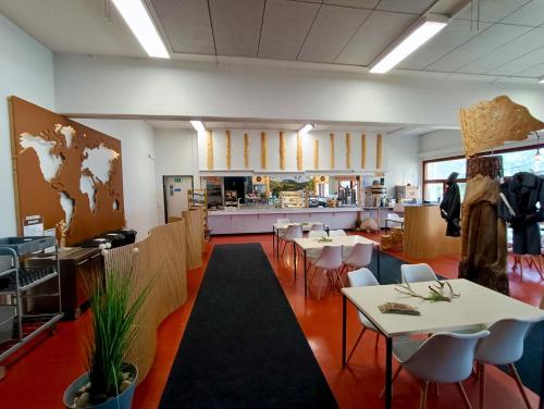 a restaurant with tables and chairs and a kitchen at Goiglo Hotel & Hostel in Kuusamo