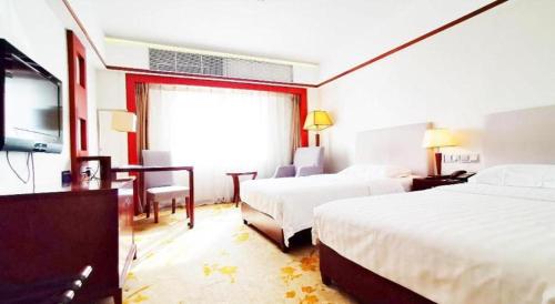 a hotel room with two beds and a flat screen tv at Starmoon Hotel in Beijing