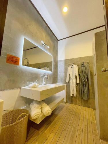 a bathroom with a sink and a mirror and towels at Vivi Bungalows Resort in Nai Harn Beach