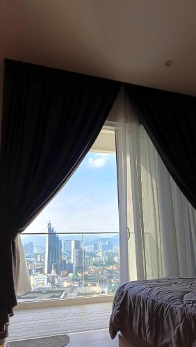 a bedroom with a large window with a view of a city at Quill Residence- Minimalist Urban Condo by Azmila in Kuala Lumpur