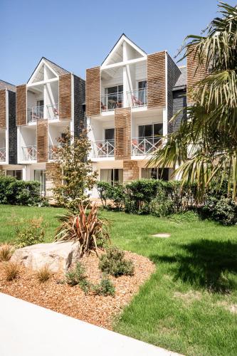 an apartment building with balconies and a yard at Thalazur Carnac in Carnac