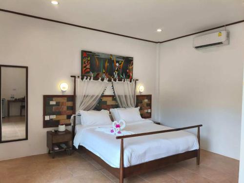 a bedroom with a bed with a pink bow on it at Vivi Bungalows Resort in Nai Harn Beach