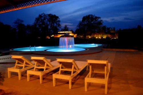 a group of chairs and a fountain at night at Aranyak Resort in Tāla