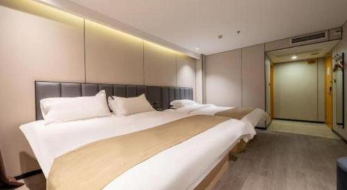 a bedroom with two large beds with white pillows at GreenTree Inn Shanghai Railway Station Macao Road in Shanghai